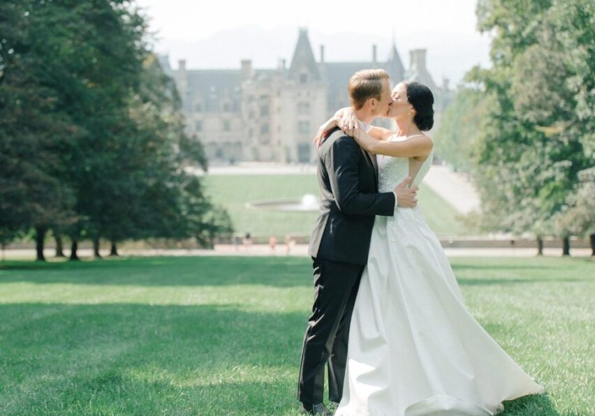 bride and groom kiss on lawn of Biltmore Asheville